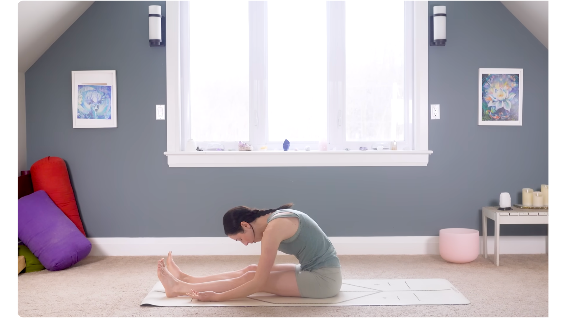 Woman sitting on a mat and leaning forward in a hamstring stretch